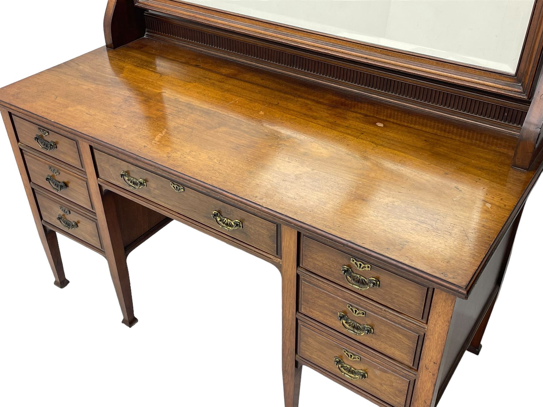 Late 19th century walnut dressing table, wide rectangular bevelled swing mirror in moulded frame, shaped horns carved with scrolls, moulded rectangular top over seven drawers, on square tapering supports with spade feet 