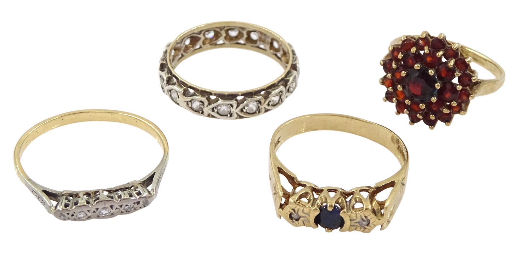 Three 9ct gold stone set rings, including cubic zirconia half eternity, sapphire and diamond three stone and garnet cluster and a gold five stone diamond chip ring