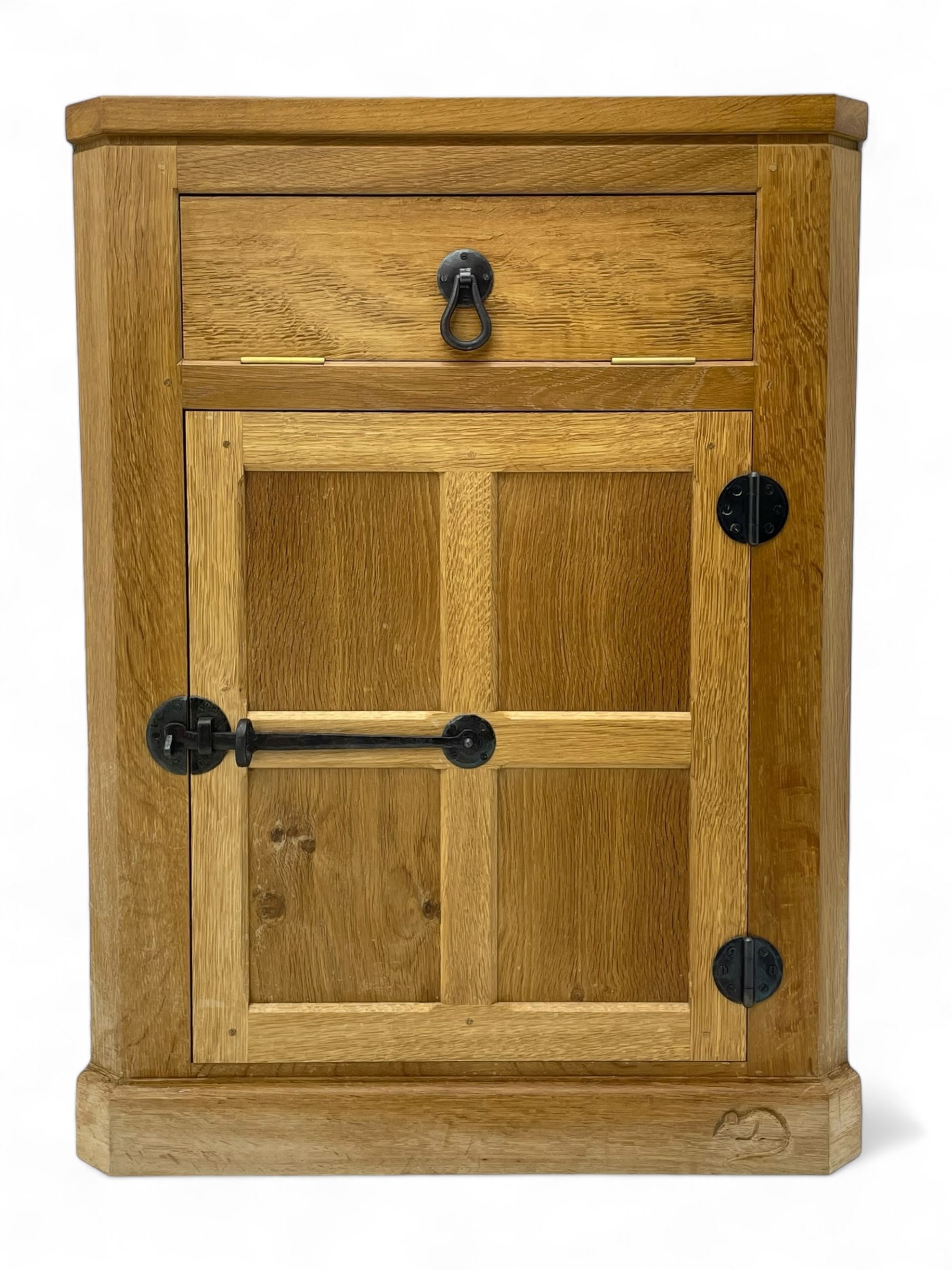 Mouseman - oak floor standing corner cupboard, fall front compartment over single panelled door, with wrought metal loop handle and latch, on moulded plinth base, carved in relief with mouse signature, by the workshop of Robert Thompson, Kilburn 