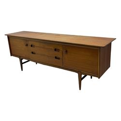 Younger - mid-20th century teak sideboard, rectangular top over three central drawers with recessed handles, flanked by two cupboard doors enclosing two shelves, on tapered supports joined by stretchers