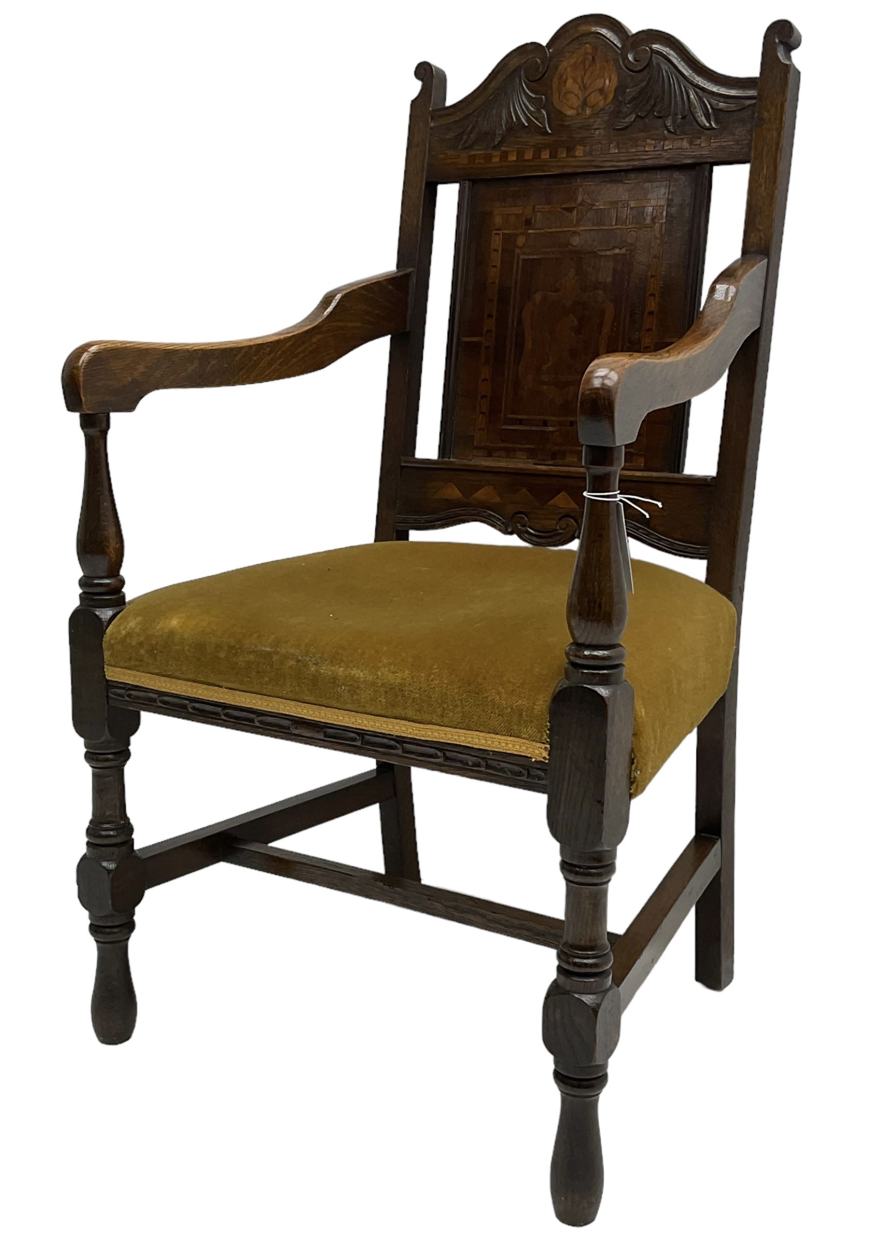 Late 19th to early 20th century oak elbow chair, the shaped cresting rail carved with scrolls and foliage, panelled back inlaid with parquetry work and central rampant lion within shield, upholstered seat, on turned supports joined by H stretchers