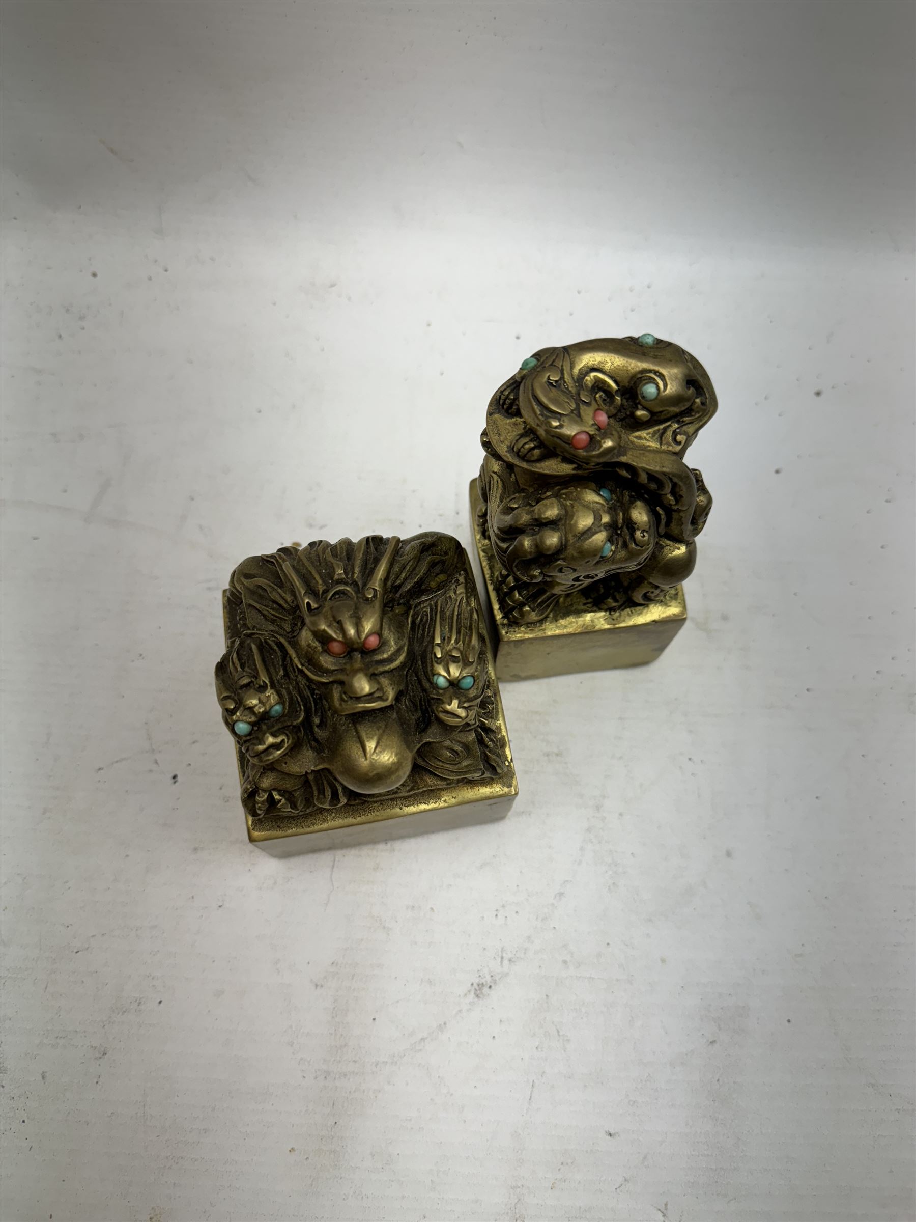 Two contemporary Chinese solid cast brass dragon desk seal, set with turquoise and coral eyes