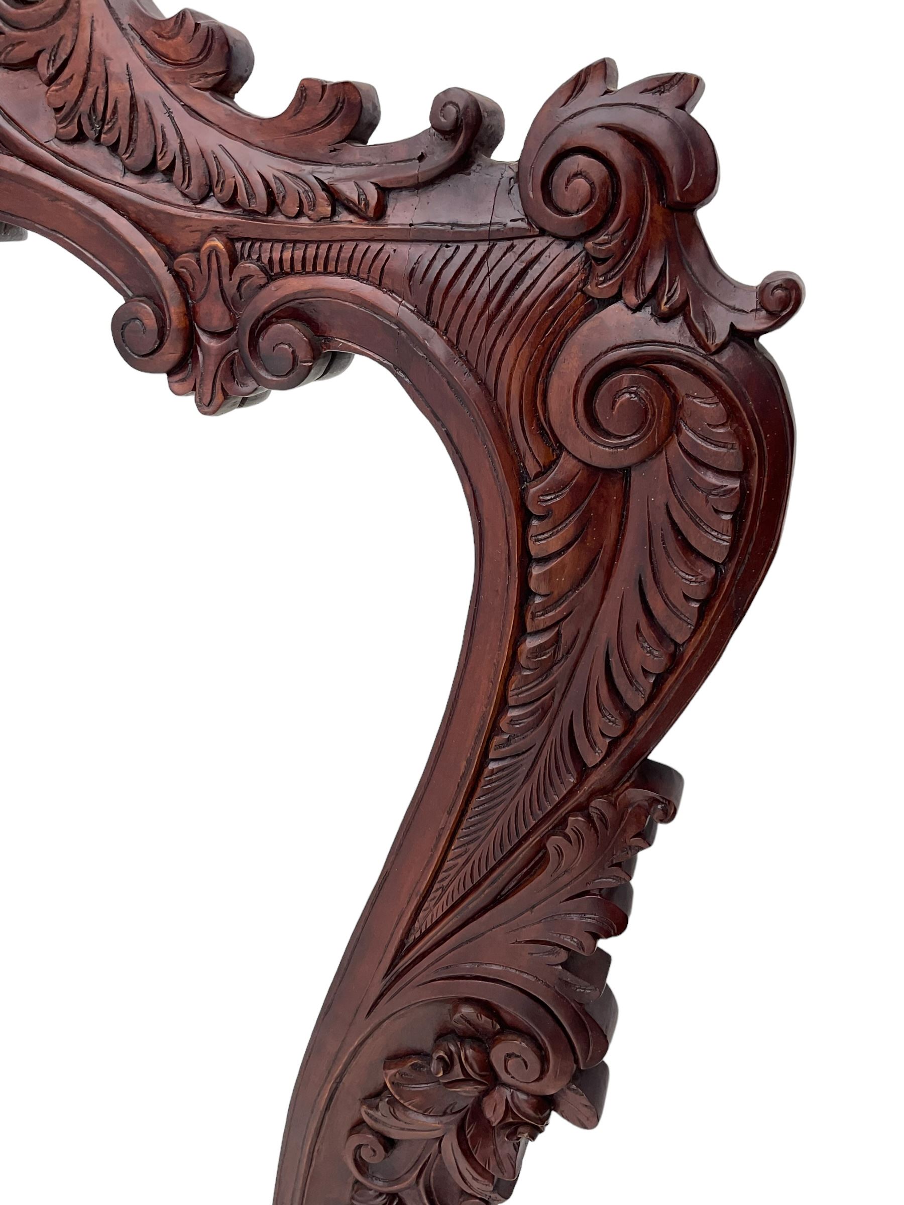 Large carved hardwood wall mirror, shaped floral carved pediment over trailing and scrolled foliage decoration, plain mirror plate 