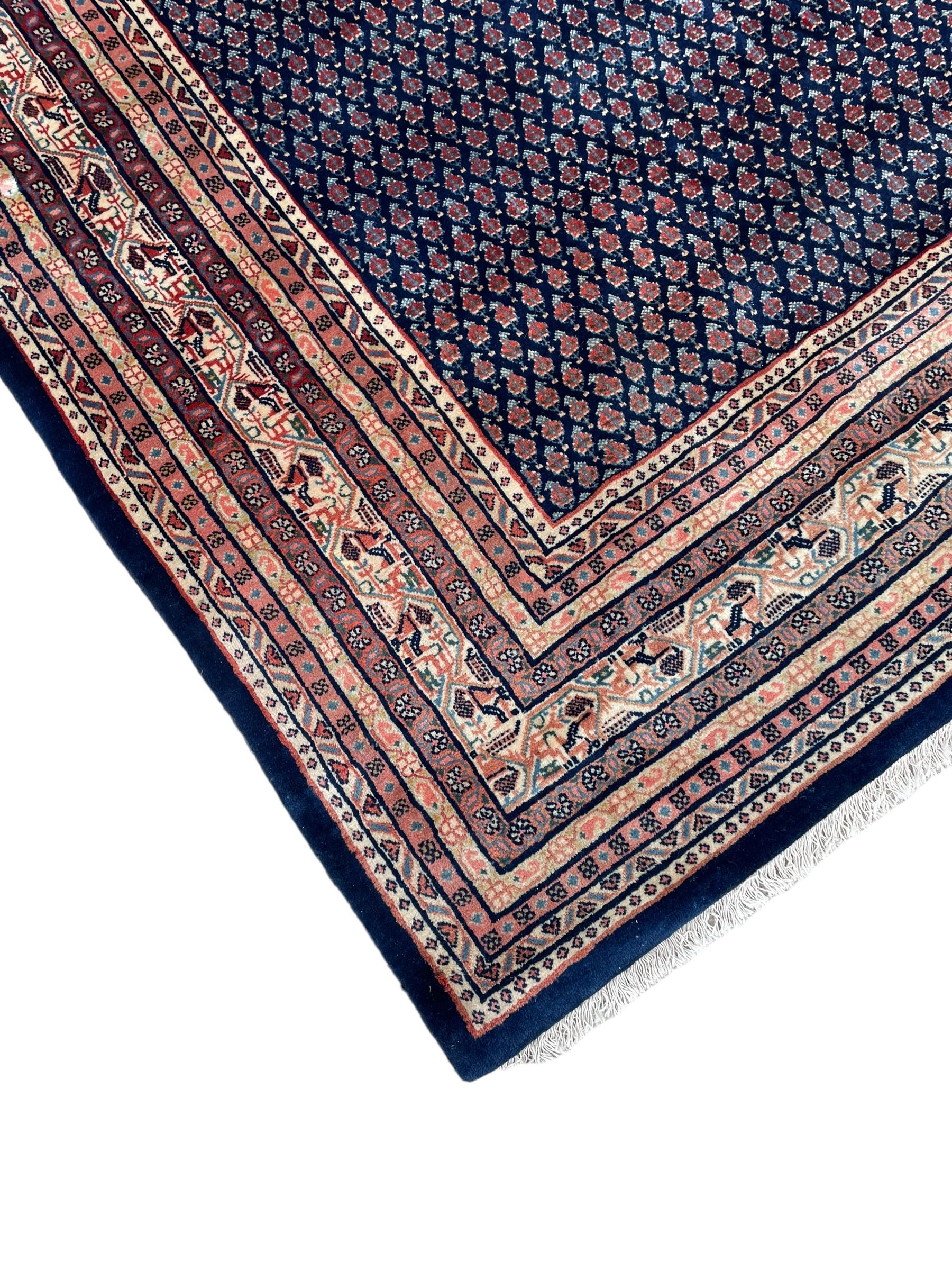 Large North-West Persian Arrak indigo ground carpet, the field decorated all-over with small Boteh motifs, multiple band border decorated with repeating geometric designs