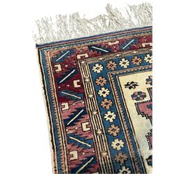 Turkish camel ground rug, three medallions surrounded by geometric motifs, the border decorated with stylised leaf motifs