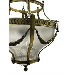 Edwardian brass ceiling light of circular bulbous form, moulded upper band over a guilloche cast central band united by shaped strapping, decorated with fruiting foliage festoons, fitted with frosted and vertical bevelled glass bowl, acanthus cast finial 