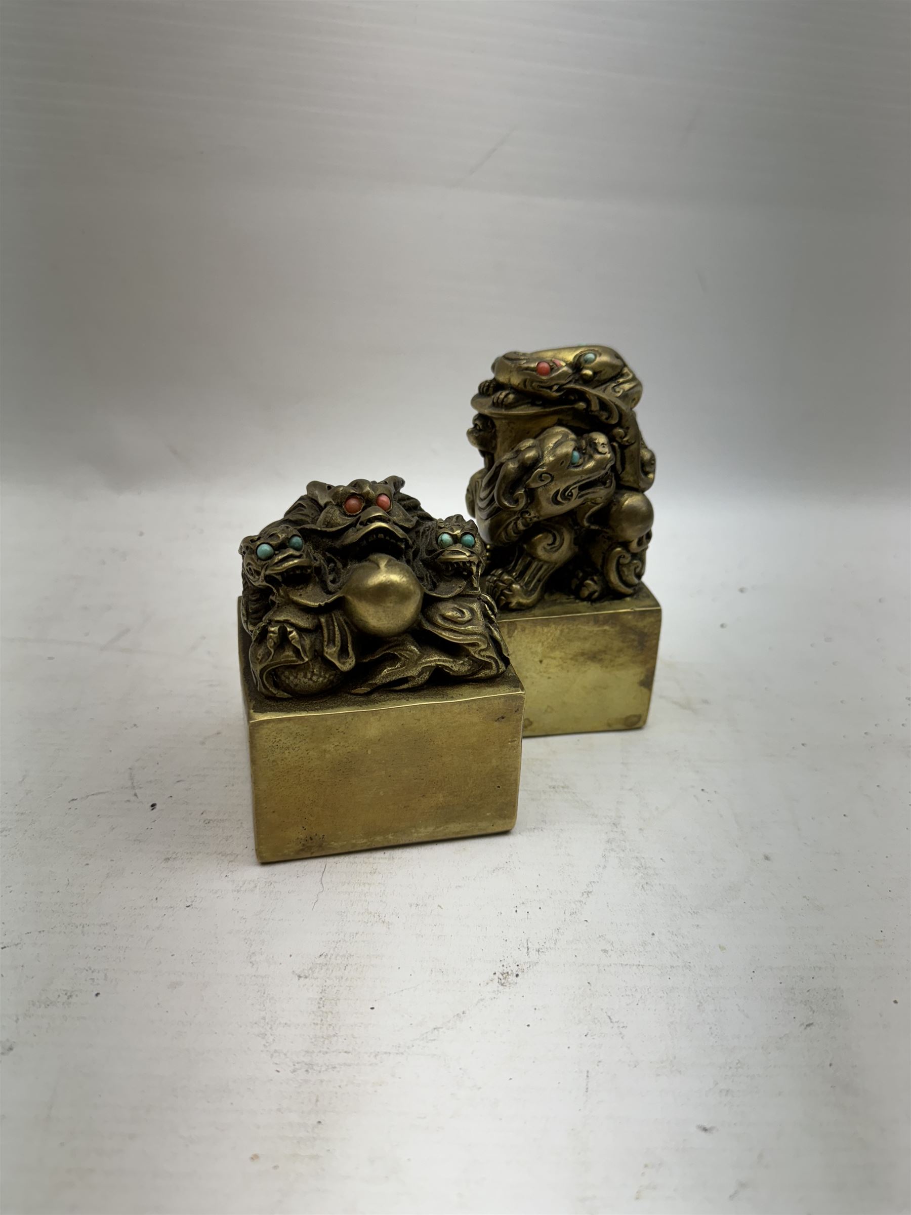 Two contemporary Chinese solid cast brass dragon desk seal, set with turquoise and coral eyes