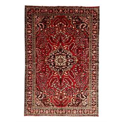 Persian crimson ground rug, central floral pattern medallion surrounded by trailing foliat...