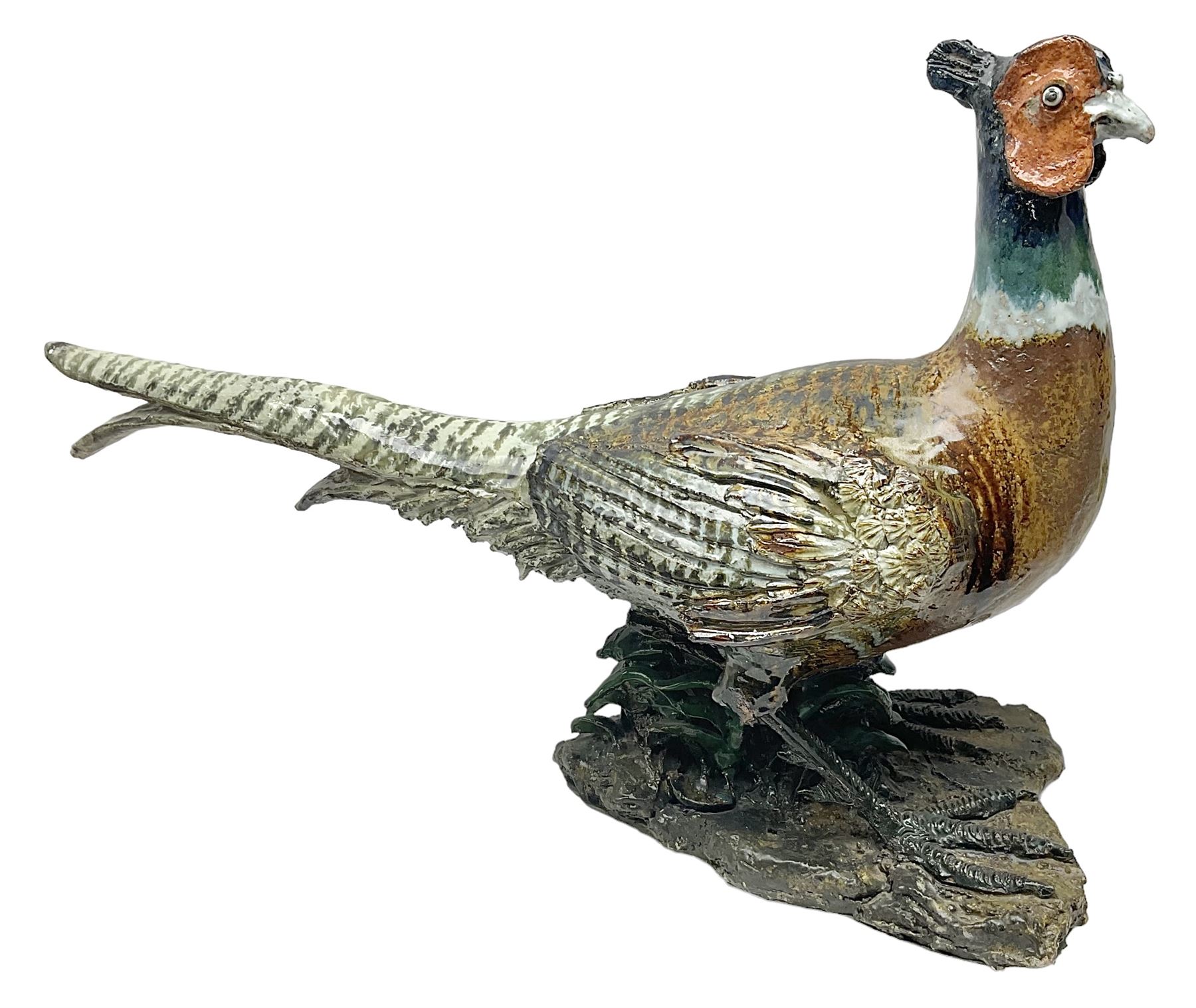 Large stoneware sculpture modeled as a Ring Neck Pheasant, upon a naturalistic base, H55cm, L78cm