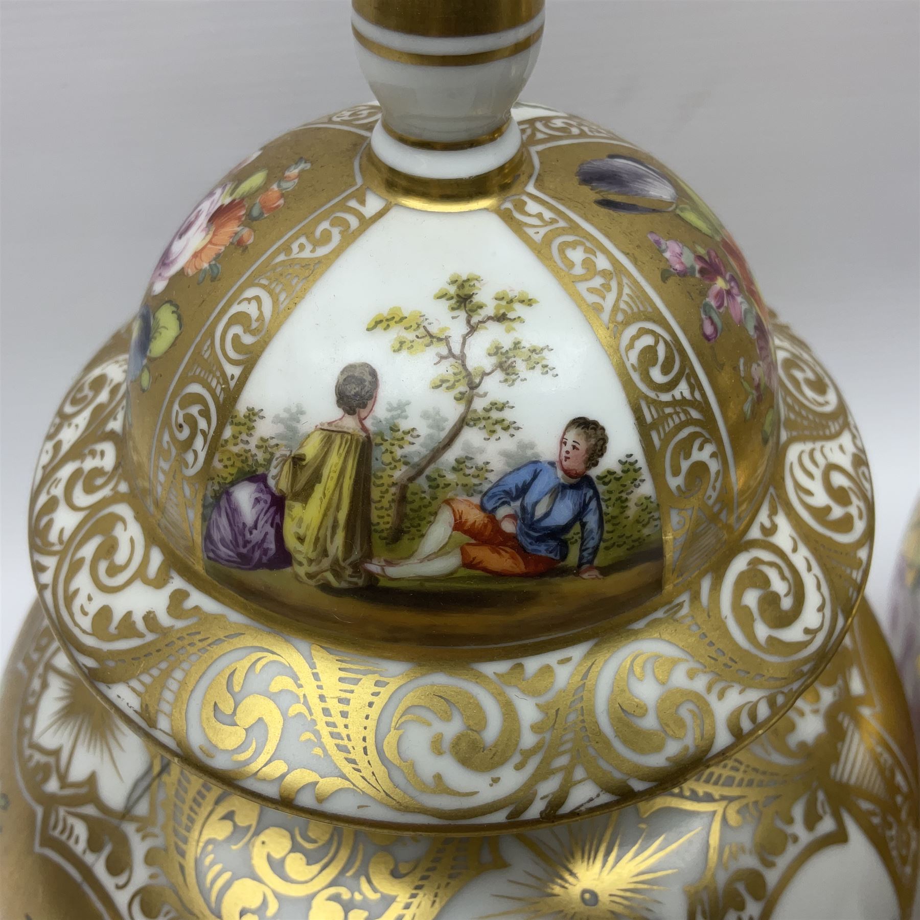 Pair of late 19th century Helena Wolfsohn vases and covers, each of baluster form with domed cover, painted with alternating panels of romantic scenes and floral sprays upon gilt ground, with Augustus Rex mark to base, H27cm