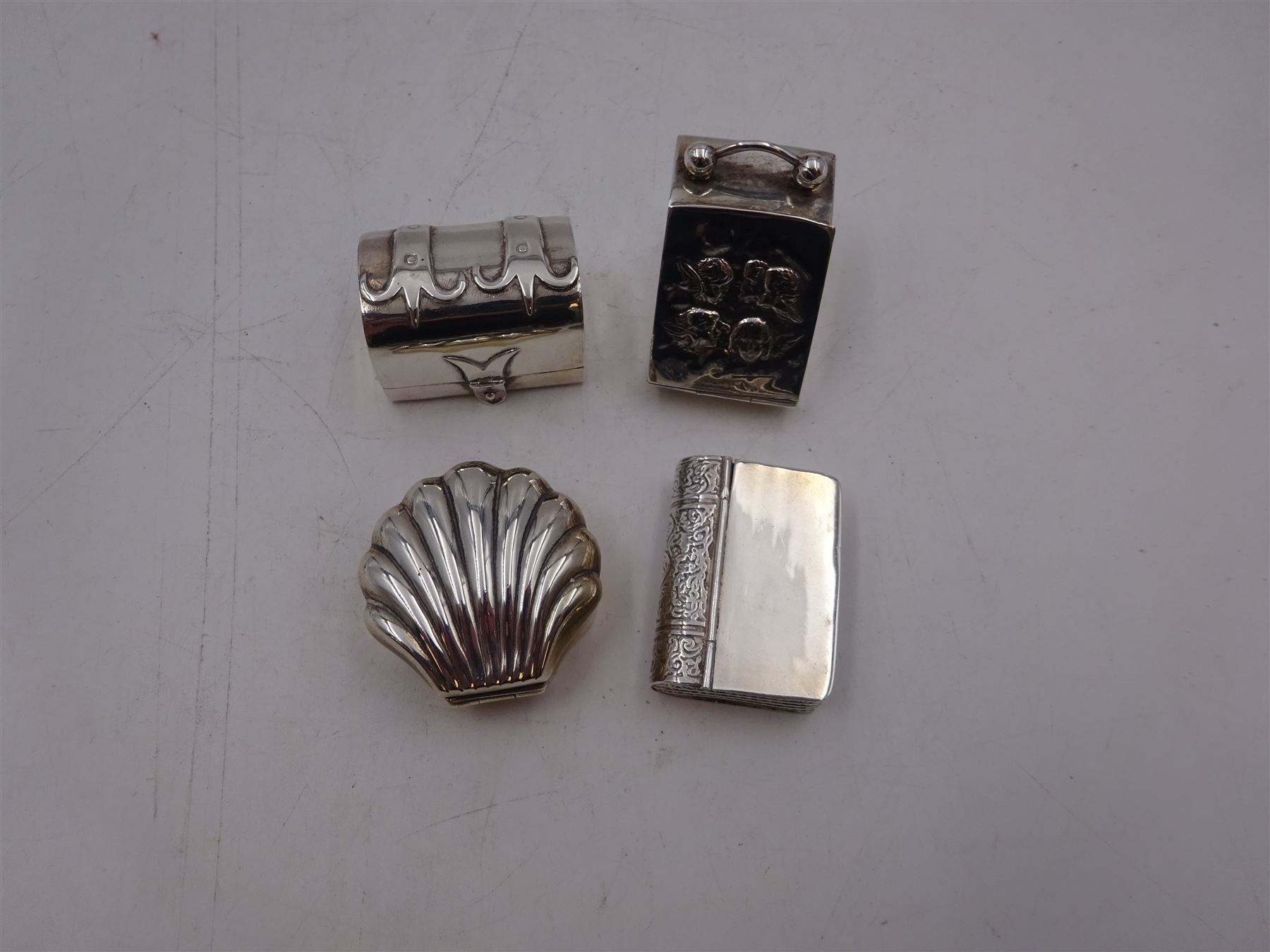 Four novelty miniature silver boxes, comprising coal scuttle, shell, trunk and bible, all hallmarked, tallest H3.5cm