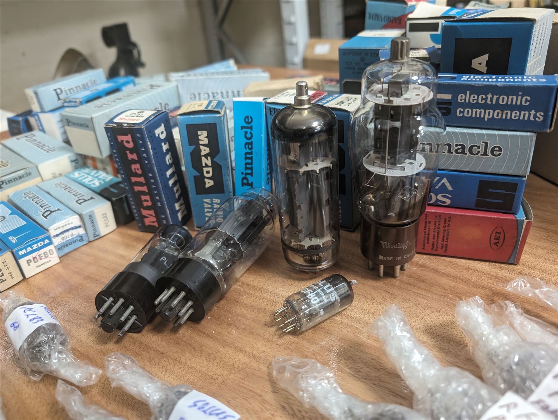 Large collection of thermionic valves/vacuum tubes, by various makers, mostly wrapped in bubble wrap with identifying stickers, together with a collection of empty valve boxes including Pinnacle, Mullard etc