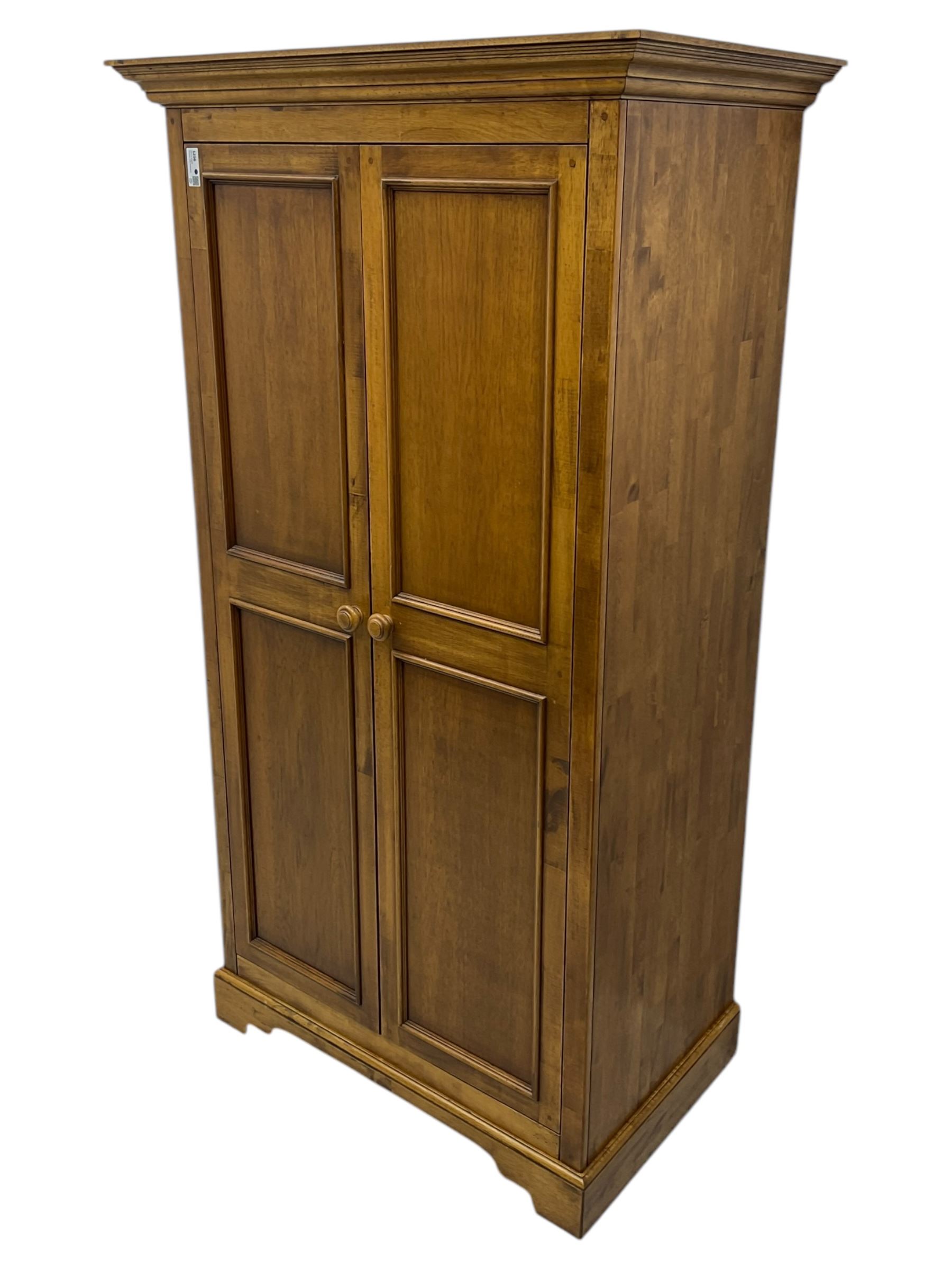 Hardwood double wardrobe, enclosed by two panelled doors, on bracket feet 