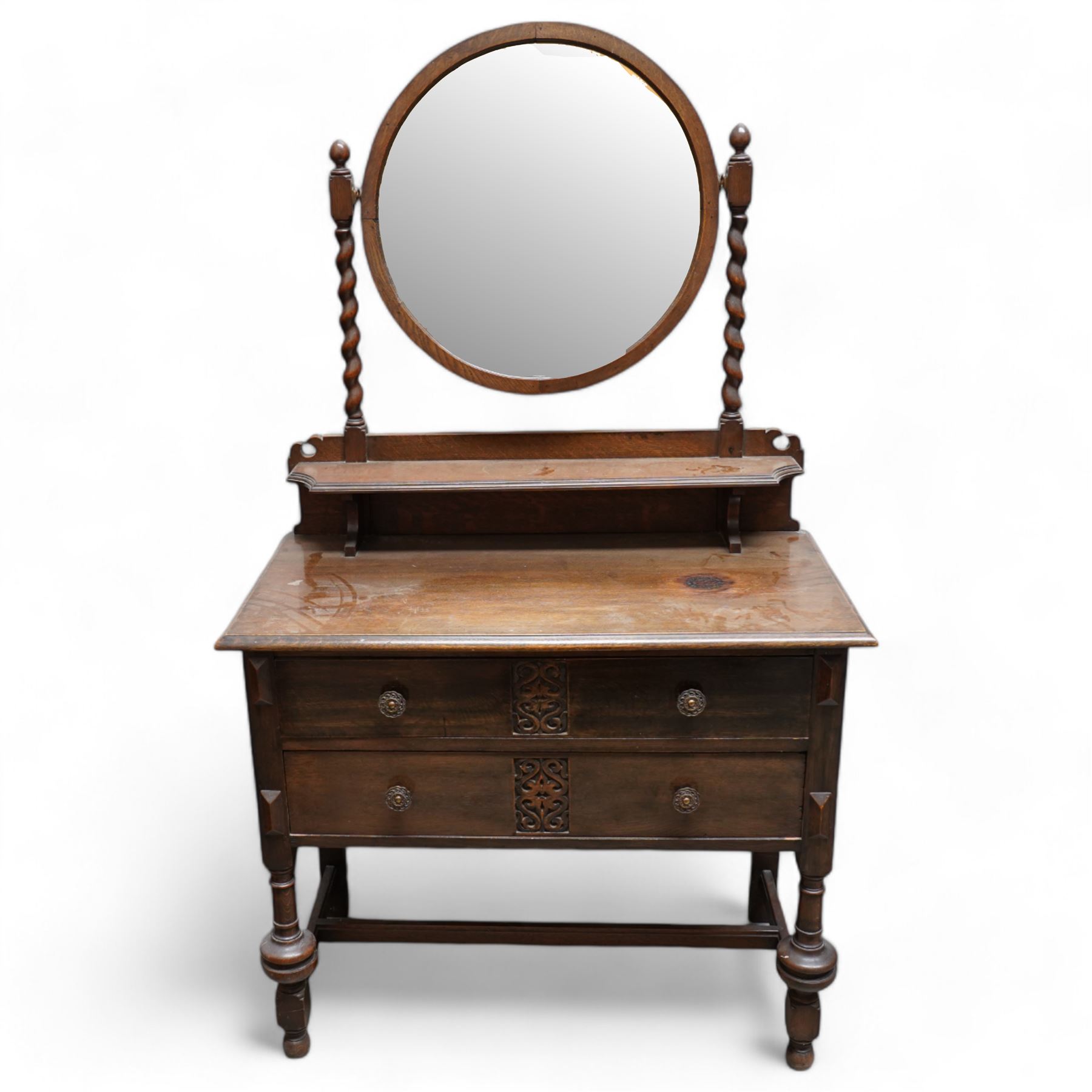 Art Nouveau oak dressing table, raised circular bevelled mirror on spiral turned supports, fitted with two drawers with scrolling foliate carvings, on turned supports joined by stretchers