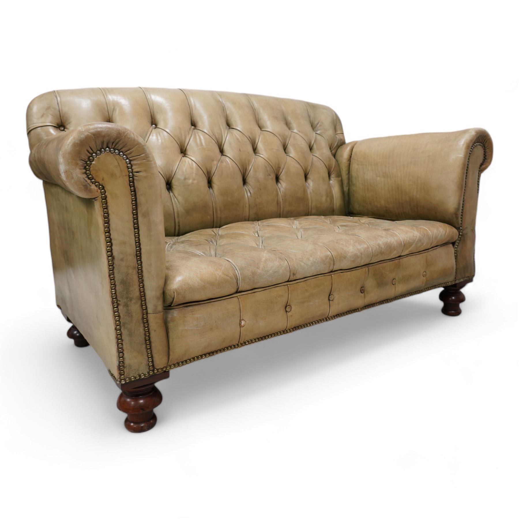 Drop-end two-seat sofa, upholstered in deeply buttoned pale green leather with stud work, on turned feet