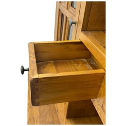 Oak dresser, upper section with twin glazed cupboard doors and central shelving with two trinket drawers, lower section fitted with six drawers over three panelled cupboard doors, raised on shaped feet 