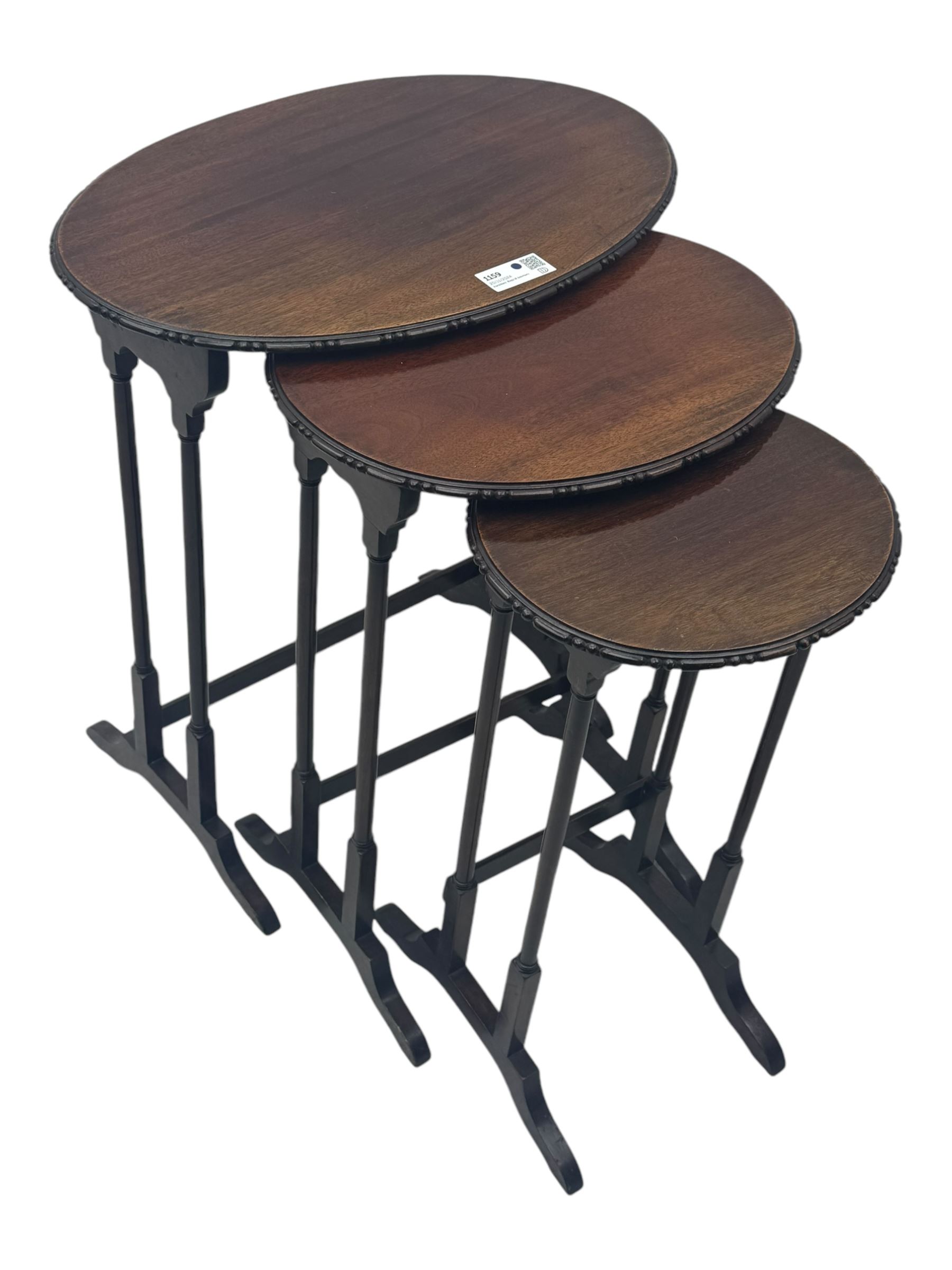 Early 20th century mahogany nest of three tables, oval tops with carved edges, turned uprights with splayed feet united by cross stretchers