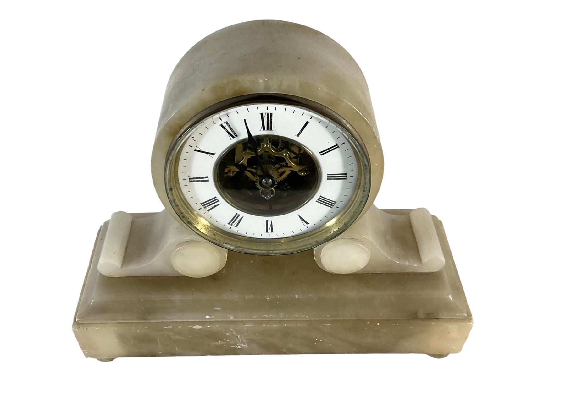 French - late 19th century 8-day mantle clock in an alabaster case,  with a drum movement raised on scroll supports and stepped plinth, open dial displaying the skeleton movement, escapement and motion work, enamel chapter with Roman numerals and spade hands enclosed within a glazed brass bezel, single train tick tac escapement with integral pendulum, wound and set from the front.