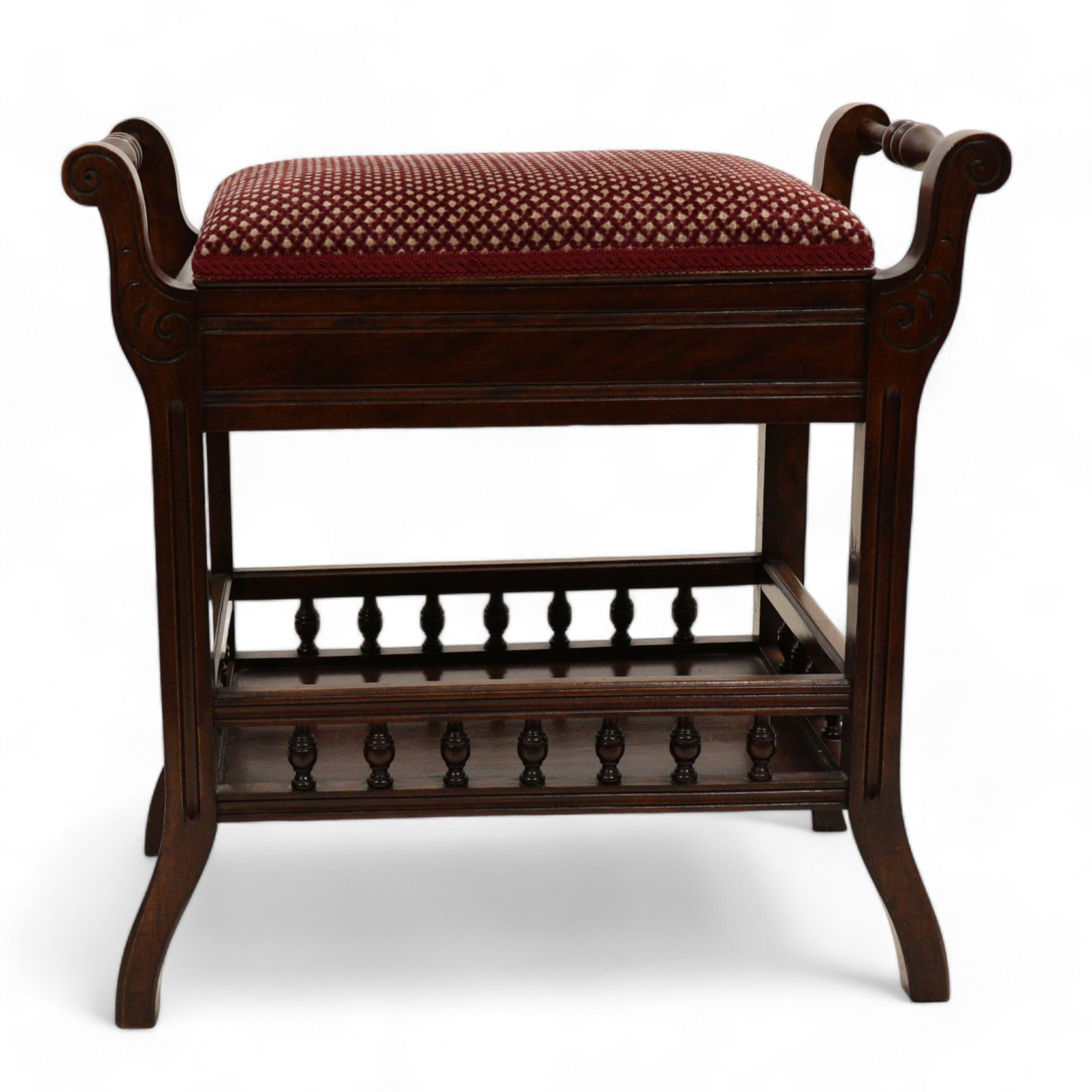 Late Victorian walnut piano stool, hinged upholstered seat enclosing storage space flanked by turnings, on S-scroll carved supports terminating to splayed feet, united by galleried undertier 