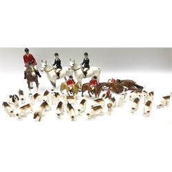 Beswick Hunting Group, comprising: two huntswoman on grey horses, model no 1730, huntsman on a bay horse, model no 1501, a seated fox, model no 1748, eighteen fox hounds and a spaniel, model no 967, all with printed marks beneath, together with three other ceramic huntsman on horseback and two hounds. 