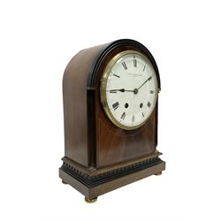 Manoah Rhodes & Son of Bradford, - Edwardian mahogany domed top mantle clock with a French 8-day movement striking the hours and half hours on coiled gong, case with inlaid stringing and raised on brass button feet, convex enamel dial with Roman numerals and steel spade hands. With pendulum and key.