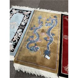 Collection of four Chinese washed woollen rugs - blue ground (153cm x 92cm); red and black ground (156cm x 94cm); light blue ground (138cm x 70cm); gold ground (153cm x 77cm)