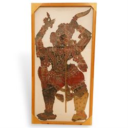 Javanese shadow puppet, painted, cut and pierced vellum, holding a knife, double sided frame 144cm x 69cm