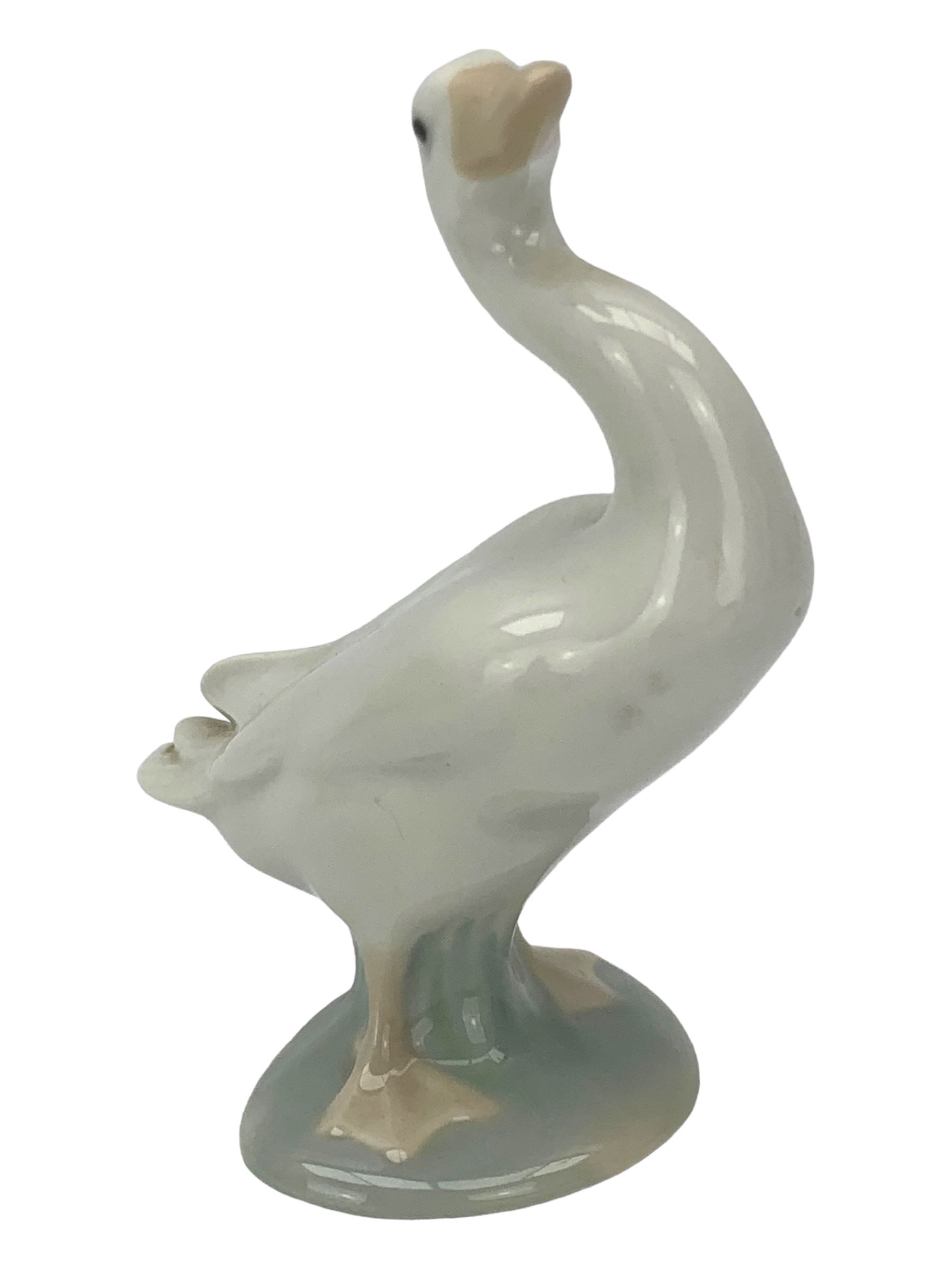 Seven Lladro figures including group of two doves, rooster, boy with accordion, deer, dove in flight , two geese and two Nao figures