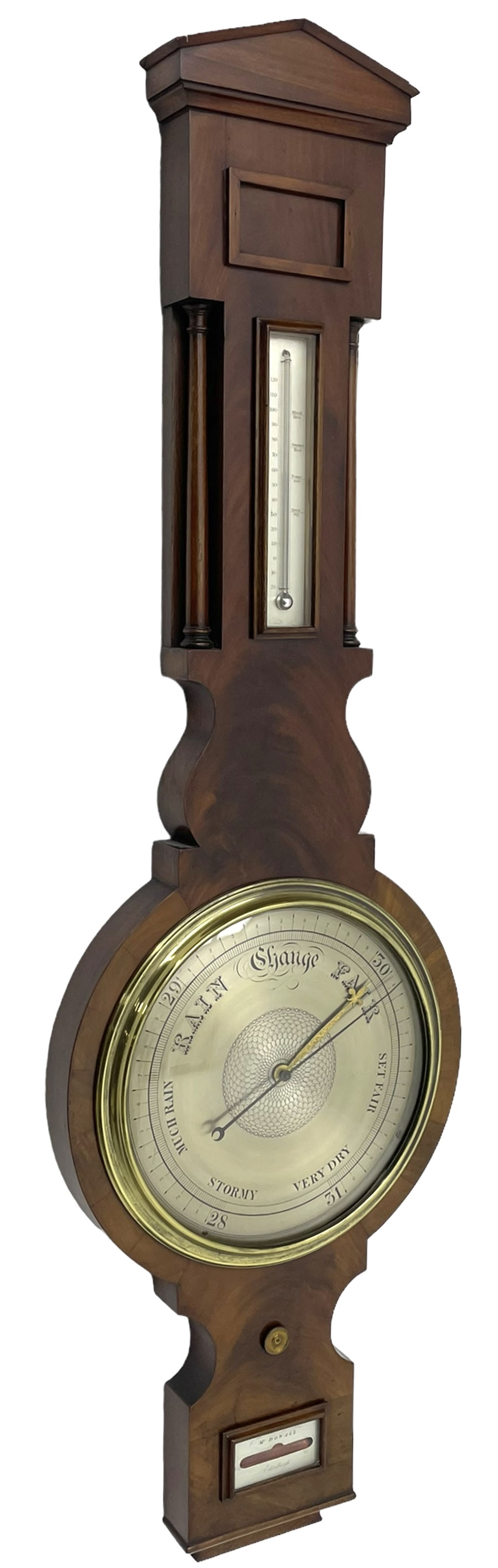 McDowall of Edinburgh - mid-Victorian mahogany mercury wheel barometer, with a gable pediment and cavetto moulded square base, cast brass bezel enclosing a 10-inch silvered register with an engraved symmetrical pattern to the centre and barometric air pressure in inches, boxed mercury thermometer with a silvered Fahrenheit scale flanked by turned wooden pilasters, brass recording hand button, rectangular spirit level signed McDowall, Edinburgh.
This barometer once formed part of the collection of Edwin Banfield, a leading authority on barometers and is illustrated in his book 