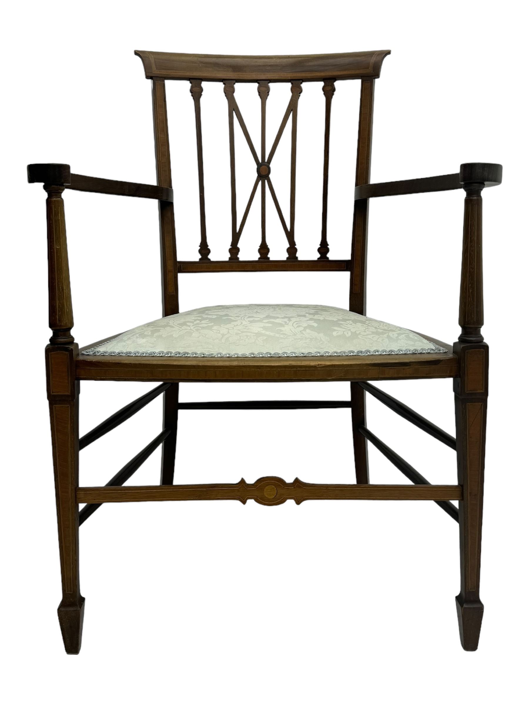 Edwardian inlaid mahogany armchair, curved top rail above spindle backrest with central X-shaped splat, the arms supported by turned uprights, over upholstered padded seat in pale blue damask fabric, on tapered supports with spade feet