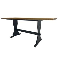 Pine dining table, rectangular top on black painted base, shaped end supports joined by pegged stretcher 