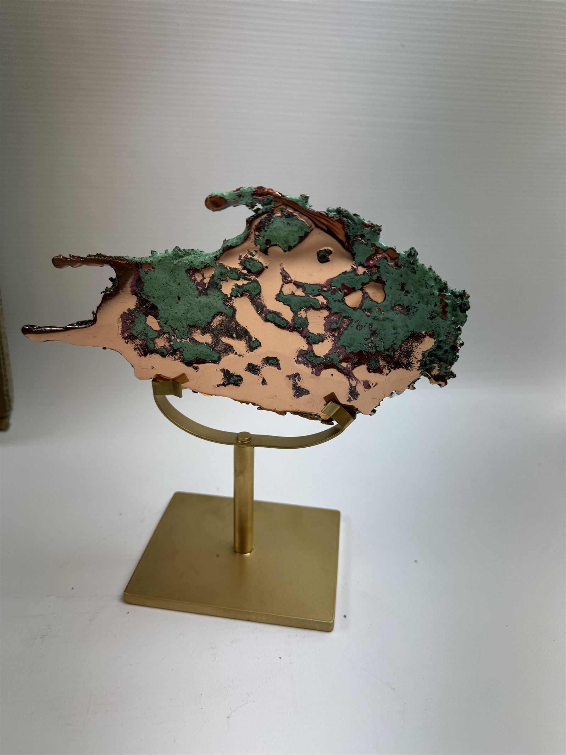 Free form copper splash, with green patina and polished copper accents, upon a gilt metal stand, H20cm 