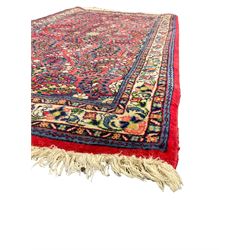 Small Persian red ground rug, the field decorated with an overall floral design, guarded ivory ground border decorated with trailing flower heads and foliage