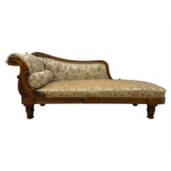 Victorian rosewood chaise longue, rolled back rest and shaped cresting rail carved with curled leaves and scrolls, upholstered in floral pattern fabric with bolster cushion, moulded lower rail with rectangular panel, on turned and lappet carved feet