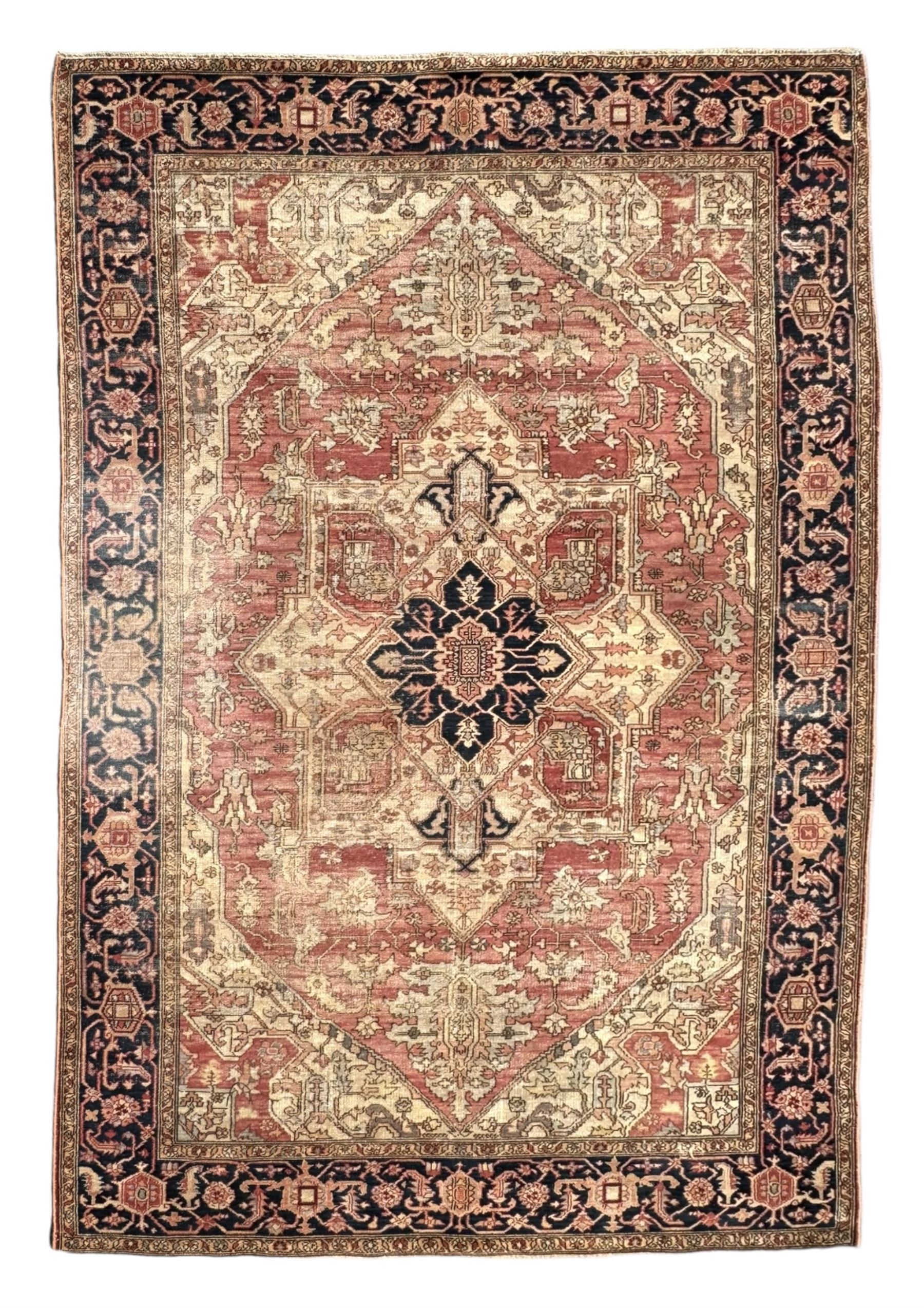 Persian Heriz design rug with red ground, the field featuring a central medallion with floral and geometric motifs, surrounded by ivory spandrels, the main border showcasing a series of floral patterns on a dark blue ground