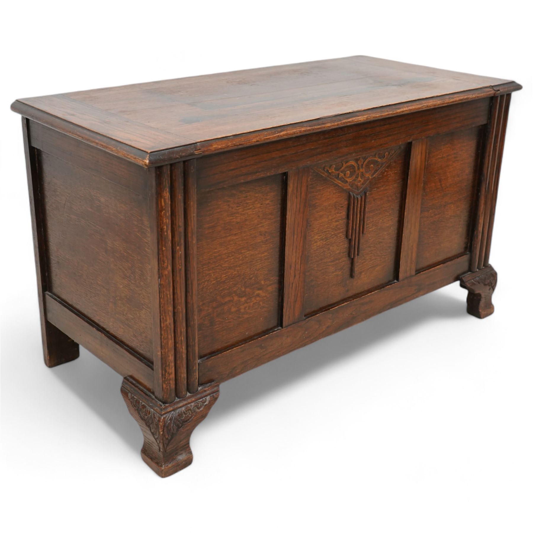 Early 20th century oak blanket chest, rectangular hinged top over triple panelled front with moulded decoration, on foliate carved ogee feet