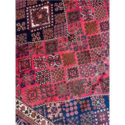 Persian Joshaghan red ground rug, the medallion, field and spandrels decorated with Pitrak and tree of life motifs, the border with repeating design decorated with stylised plant motifs, within guard stripes