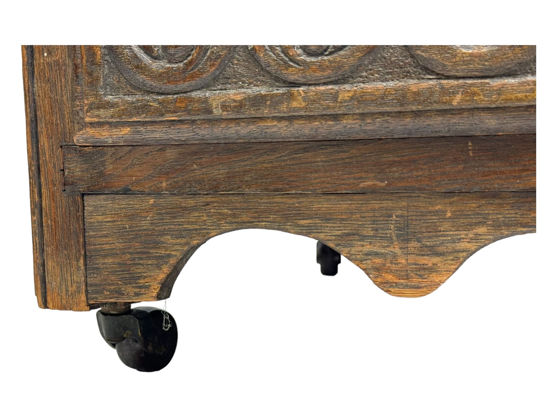 Victorian carved oak kneehole desk, the rectangular top with carved edge, above central drawer with carved front and brass handles, central kneehole with cupboard door, flanked by two banks of three graduating drawers each with similarly carved decoration, on shaped plinth base with castors