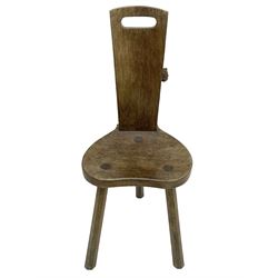 Rabbitman - oak spinning or hall chair, the rectangular tapering back with pierced handle carved with rabbit signature, dished kidney-shaped seat, on three splayed supports, by Peter Heap, Wetwang