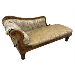 Victorian rosewood chaise longue, rolled back rest and shaped cresting rail carved with curled leaves and scrolls, upholstered in floral pattern fabric with bolster cushion, moulded lower rail with rectangular panel, on turned and lappet carved feet