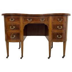 Edwardian mahogany and satinwood banded kidney-shaped writing desk, the shaped top with figured mahogany banding and boxwood stringing, fitted with seven drawers with satinwood bandings, on square tapering supports with brass and ceramic castors