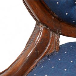 Victorian carved walnut framed nursing chair, the cresting carved with flower heads and extending foliage, upholstered in buttoned blue fabric with repeating pattern, on floral carved cabriole feet