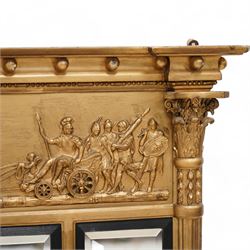 Regency gilt overmantle mirror, inverted breakfront pediment decorated with applied gilt spheres, the relief frieze depicting Magna Mater in her lion-pulled chariot with trumpet playing winged deities overhead, Roman heroes to the back of her with maidens performing rites in front, flanked by half reeded pilasters with Ionic and Corinthian composite capitals, the triple bevelled rectangular plates enclosed by reeded ebonised slips