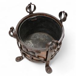 Late 19th to early 20th century Arts & Crafts wrought metal and copper coal or log basket, hammered metal frame, on four supports with bulbous onion finials terminating to pad feet, the frame decorated and united by curled stylised leaf pattern, the copper inner decorated with cabochons mounts, fitted with metal liner 