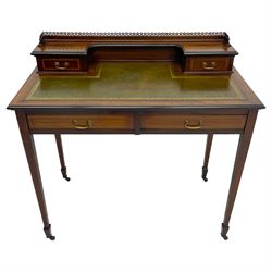 Edwardian inlaid mahogany writing desk, raised back with gilt metal gallery over two small drawers with satinwood banding, the rectangular moulded top with green leather inset writing surface, fitted with two drawers, on square tapering supports with spade feet, brass and ceramic castors 