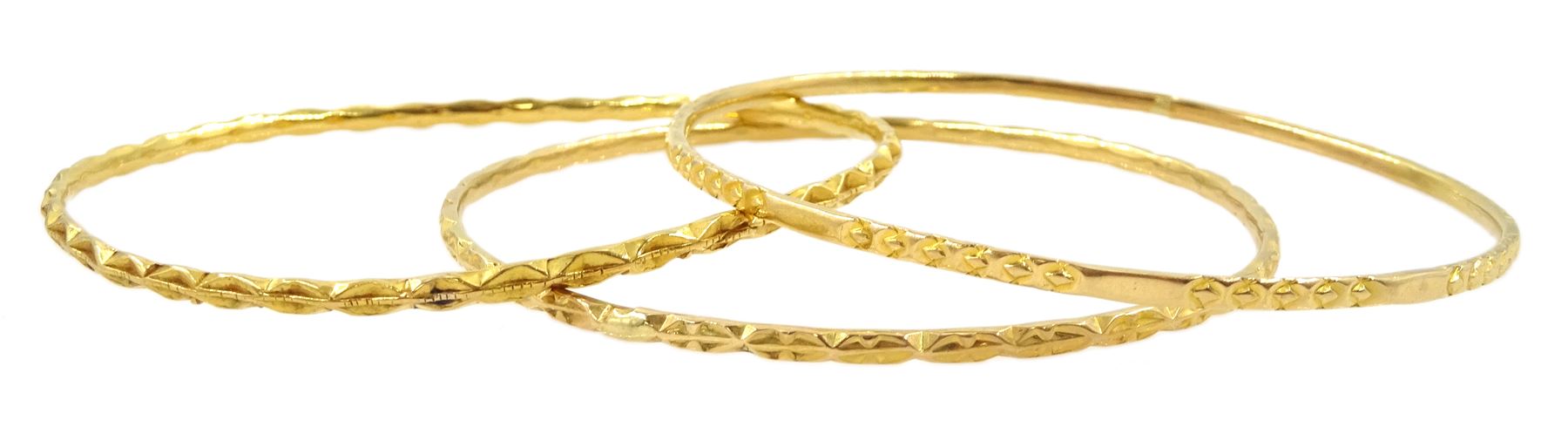 Three Middle Eastern 20ct and 21ct gold bangles