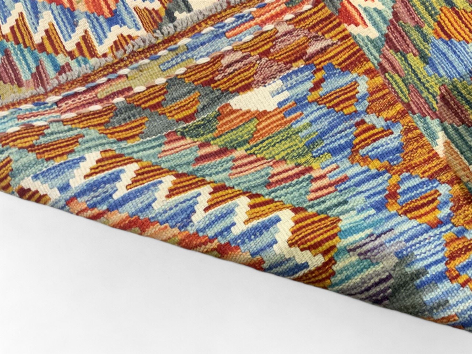 Chobi kilim multi-coloured rug, the field decorated with various lozenges of contrasting colours with ivory outlines, enclosed by a guard band with repeating geometric patterns