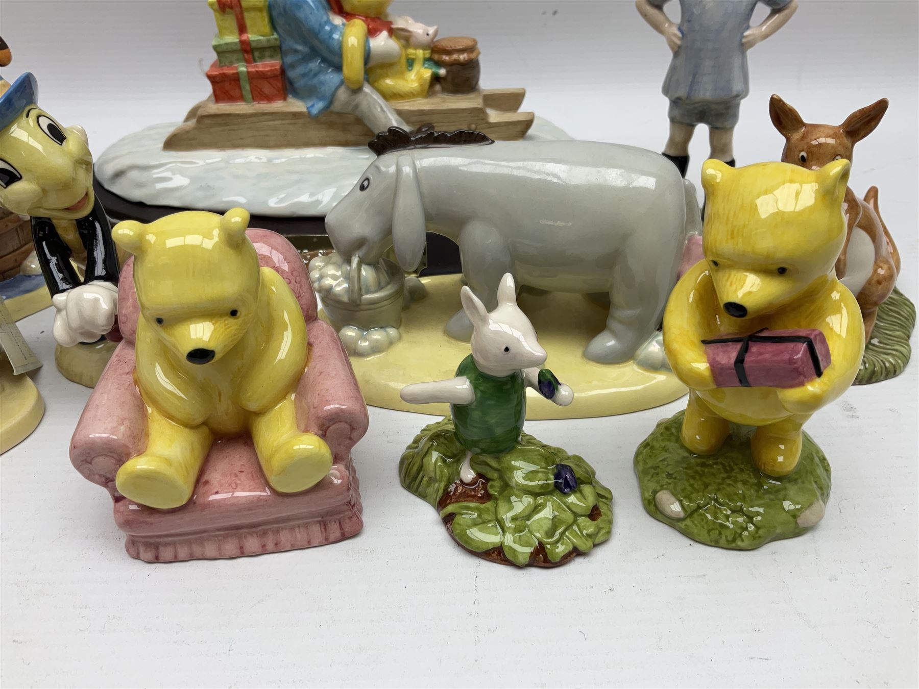 Nine Royal Doulton Winnie the Pooh Collection figures, including Oh Dear Bath Time's Here, Going Sledging, Tigger's Splash Time and Christopher Robin, together with a Royal Doulton Disney Showcase Jiminy Cricket figure, all boxed