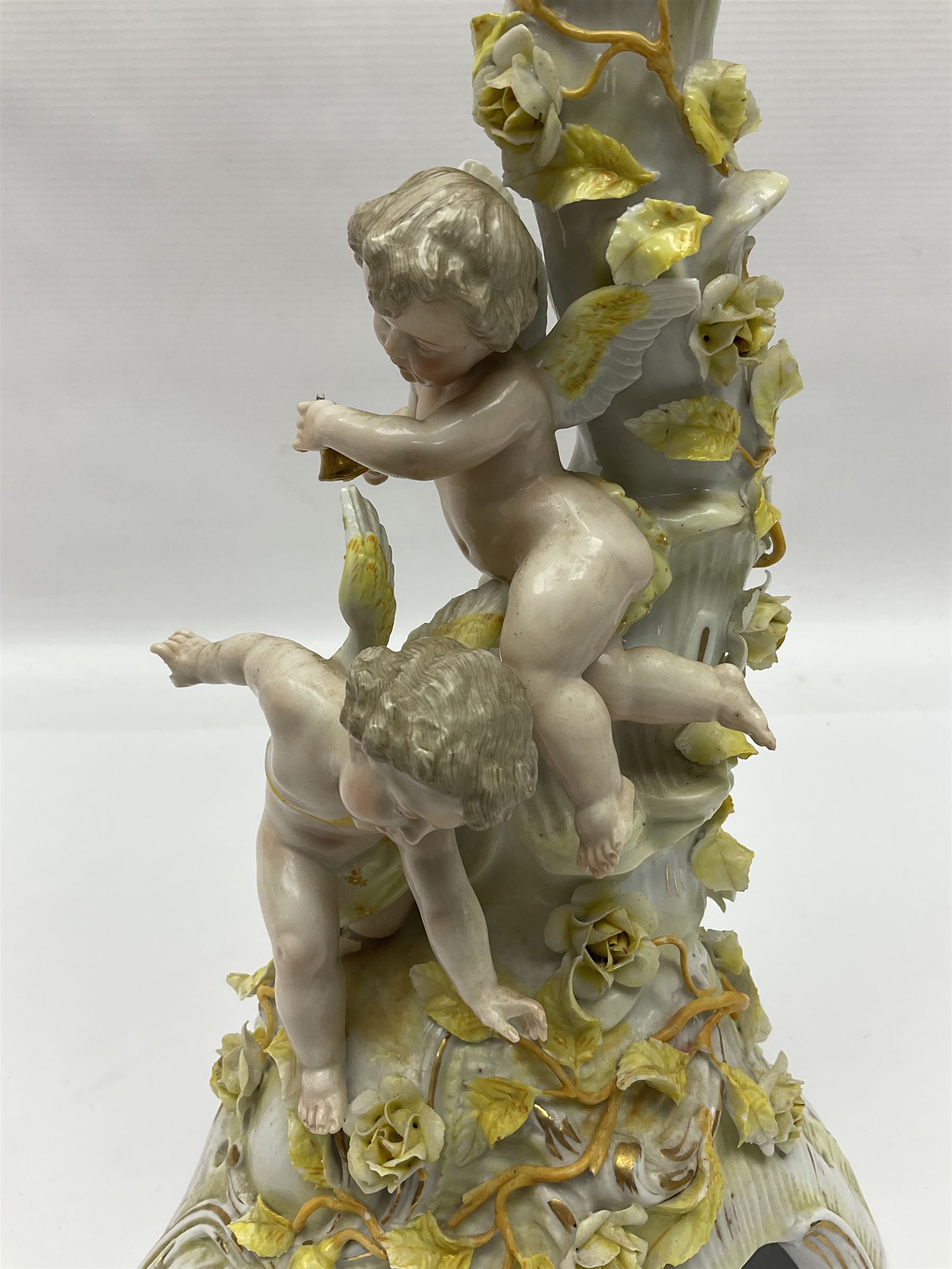 Dresden style candelabra, the central stem bordered by three branches, decorated with cherubs and yellow roses, H48cm