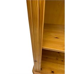 Traditional pine open bookcase, featuring arched top section flanked by fluted side supports, two adjustable shelves and cast iron coat hook with cat motif to the left side, standing on round bun feet 